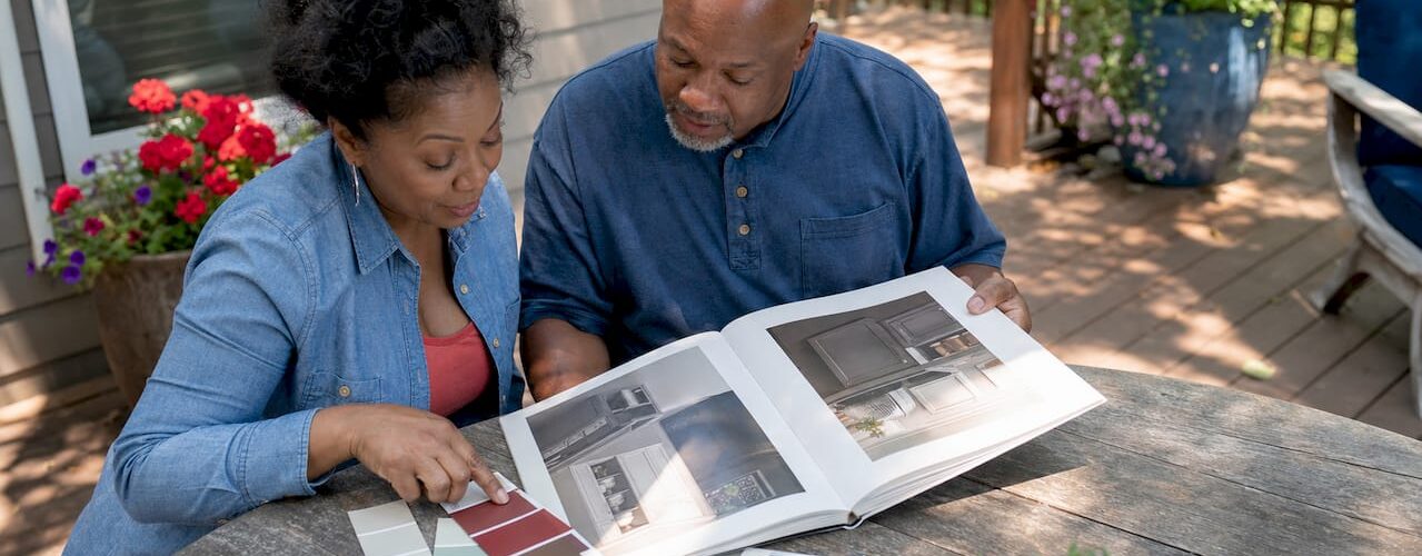 Couple comparing cabinet painting options in kitchen