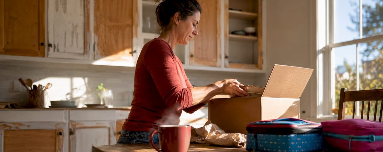 Woman unpacking in kitchen with refinishing progress