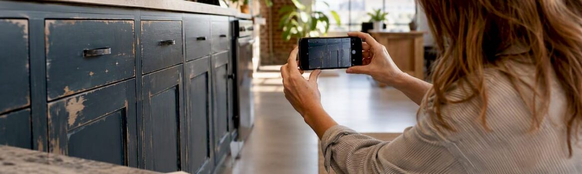Homeowner photographing kitchen cabinet damage
