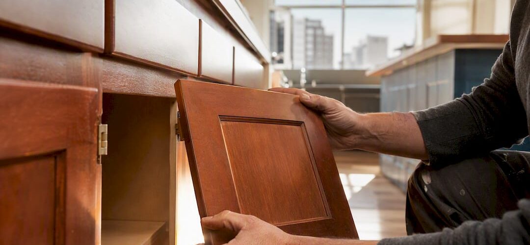 Hands removing condo kitchen cabinet doors