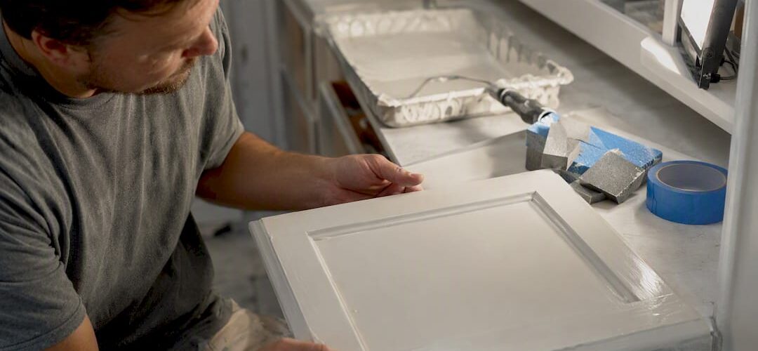 Cabinet painter checking paint drips with side light